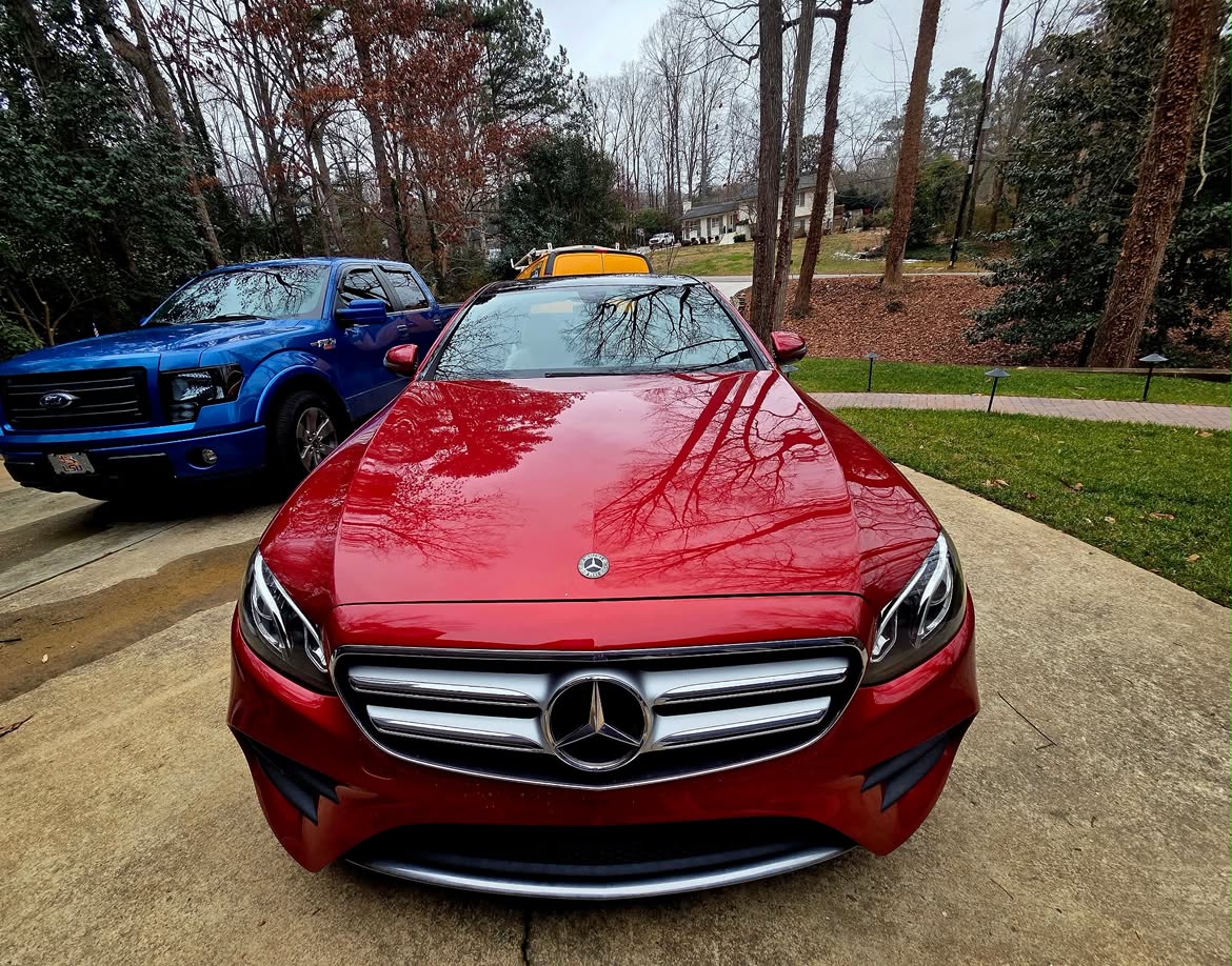 Red luxury sedan in a driveway after a mobile glass appointment